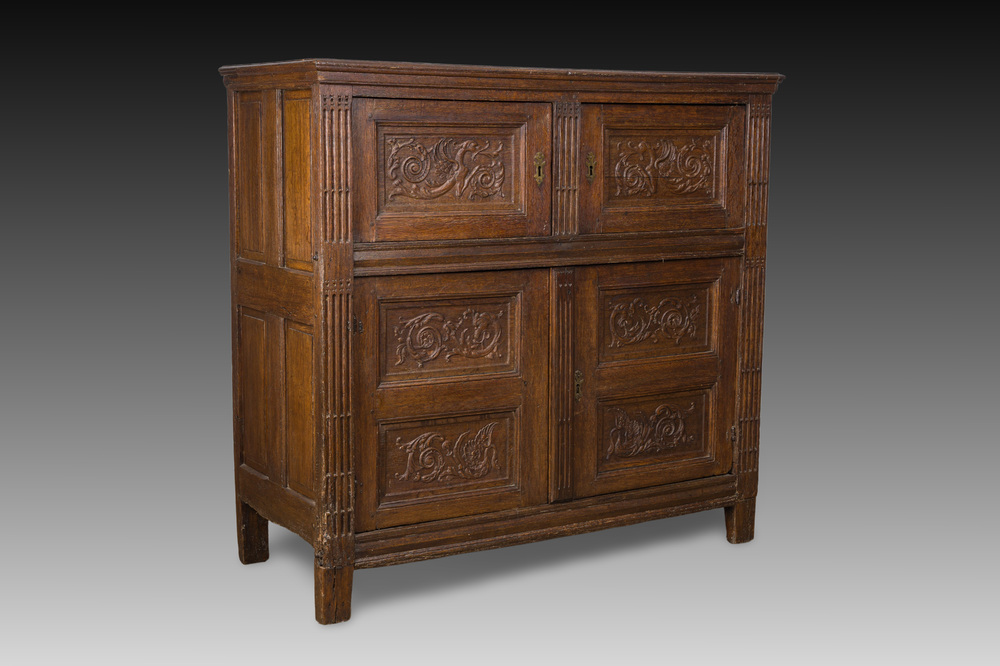 Een Vlaamse eikenhouten vierdeurkast met panelen met spuwende griffioenen, 17de eeuw