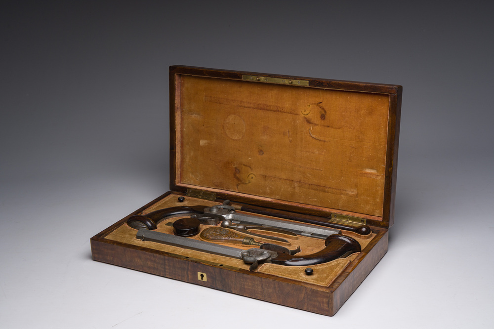 A French dueling box containing a pair of percussion pistols with damask barrels and engraved breechblocks, 19th C.
