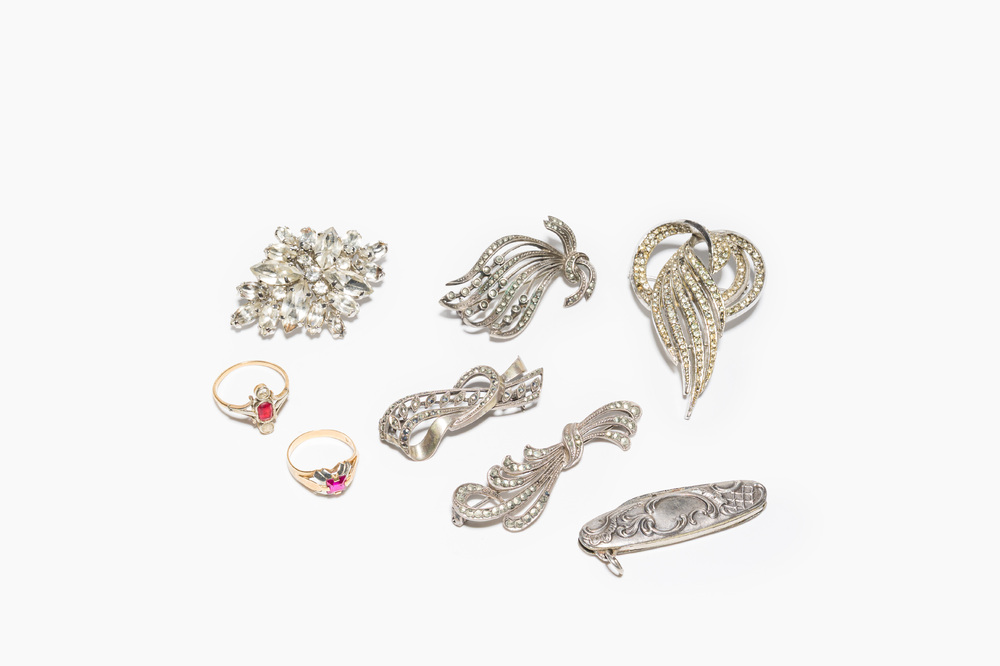 A varied collection of jewelry, including silver brooches and an 18 carat gold ring, 20th C.