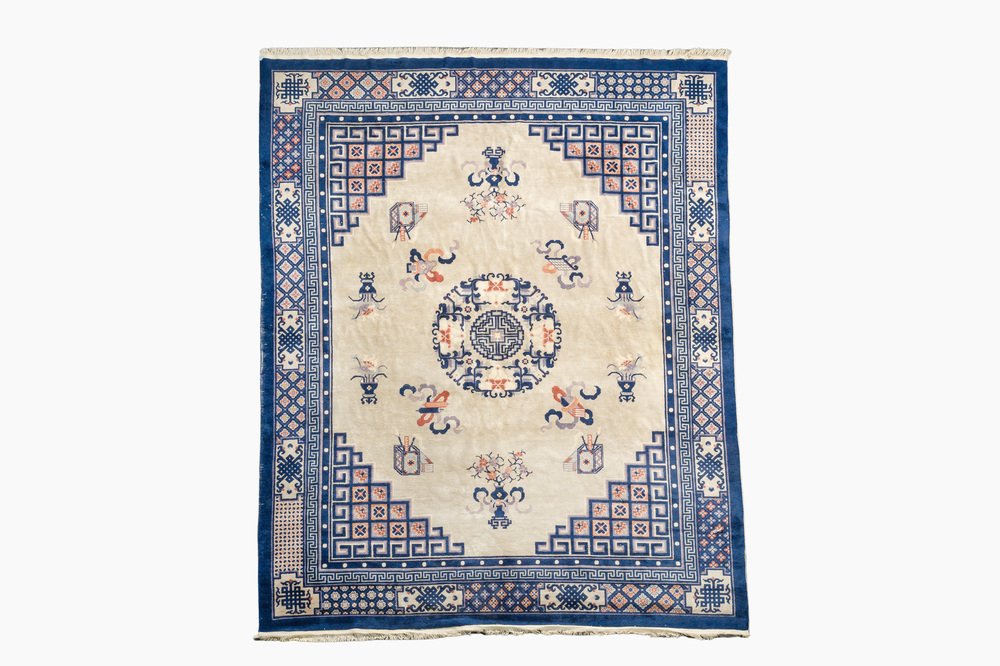 A Chinese Beijing rug with antiquities, floral design and stylized motifs, wool on cotton, 20th C.