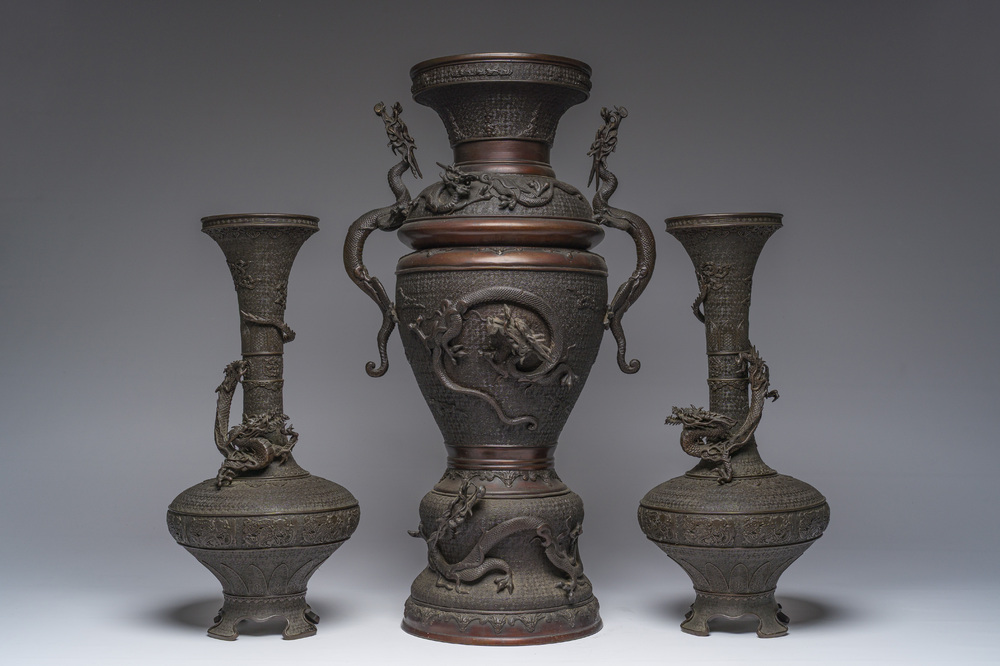 A Japanese three-piece bronze garniture with dragon relief design, Meiji, 19th C.