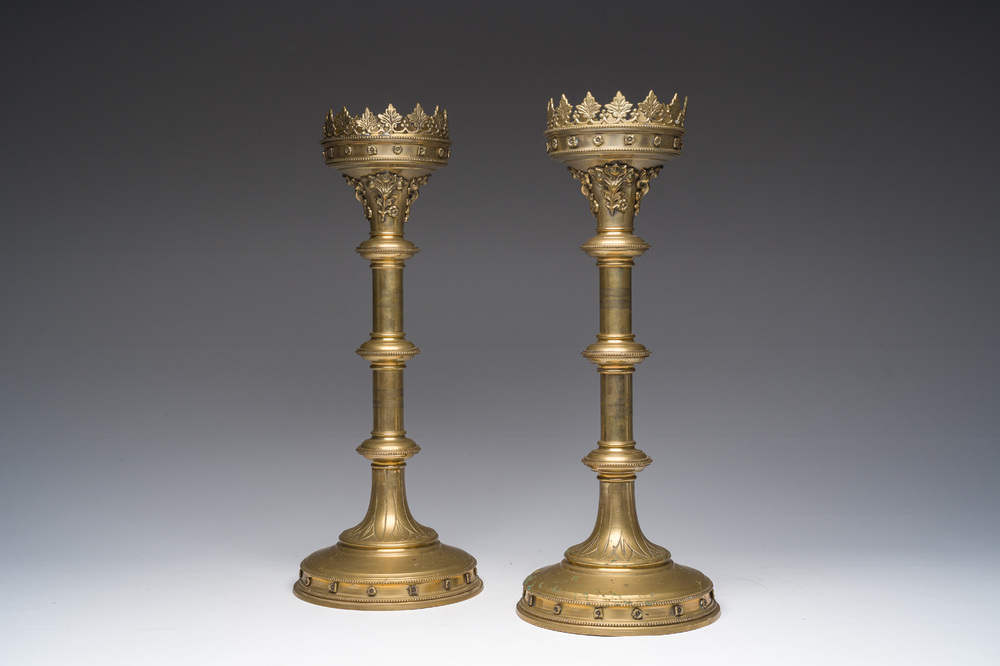 Een paar koperen deels gegraveerde neogotische kerkkandelaars met floraal reli&euml;fdecor, ca. 1900