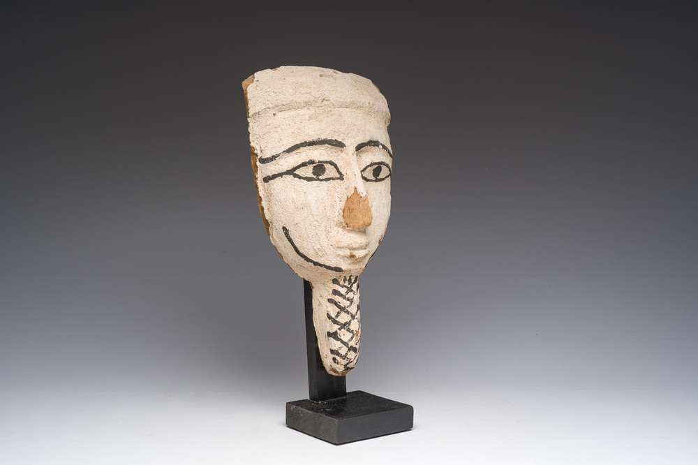 An Egyptian wooden sarcophagus mask with white stucco and black accents, Late Period, 6th-1st C. b.C.