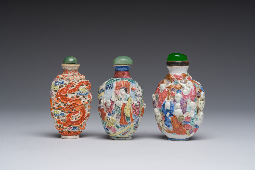 Drie Chinese famille rose snuifflessen met reli&euml;fdecor van figuren, een draak en een feniks, 19de eeuw