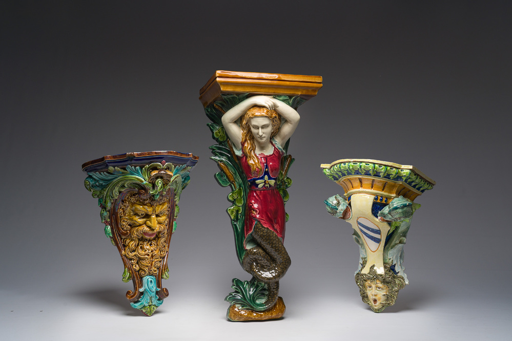 Trois consoles d'appliques en majolique polychrome &agrave; d&eacute;cor d'une sir&egrave;ne, d'un mascaron et d'un blason, une marqu&eacute;e Sarreguemines, France, d&eacute;but 20&egrave;me