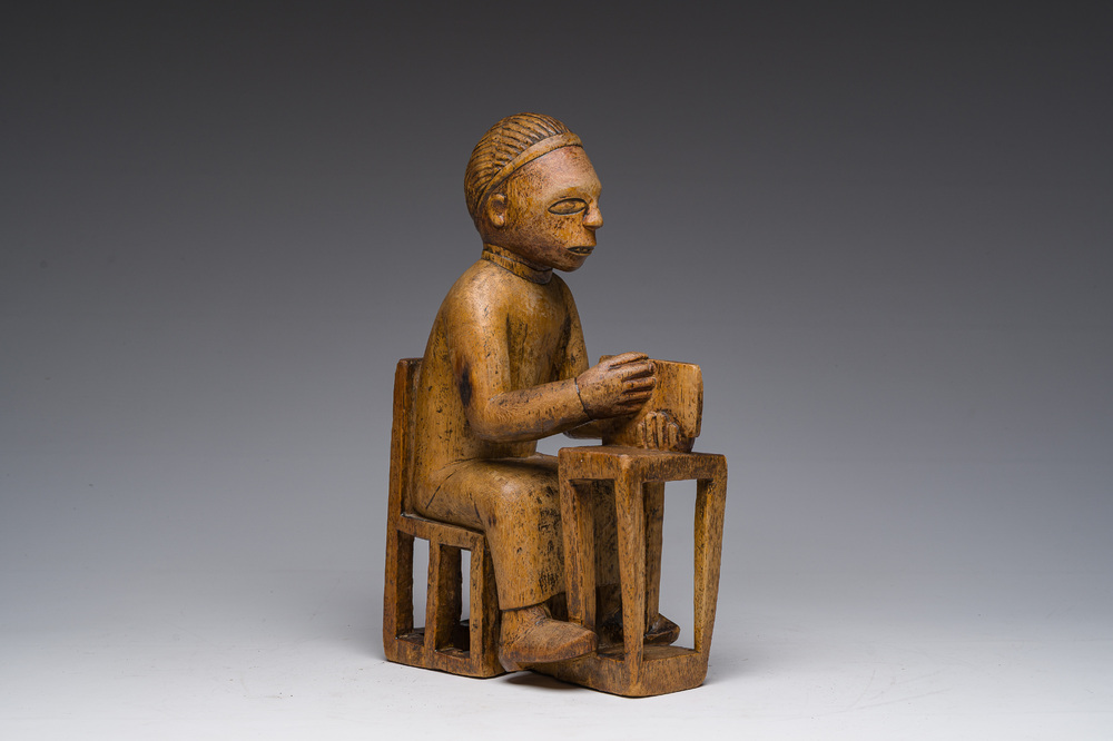 Sculpture en bois sculpt&eacute; d'un homme assis &agrave; un bureau avec un livre &agrave; la main, Bakongo, Congo, premier tiers du 20&egrave;me si&egrave;cle