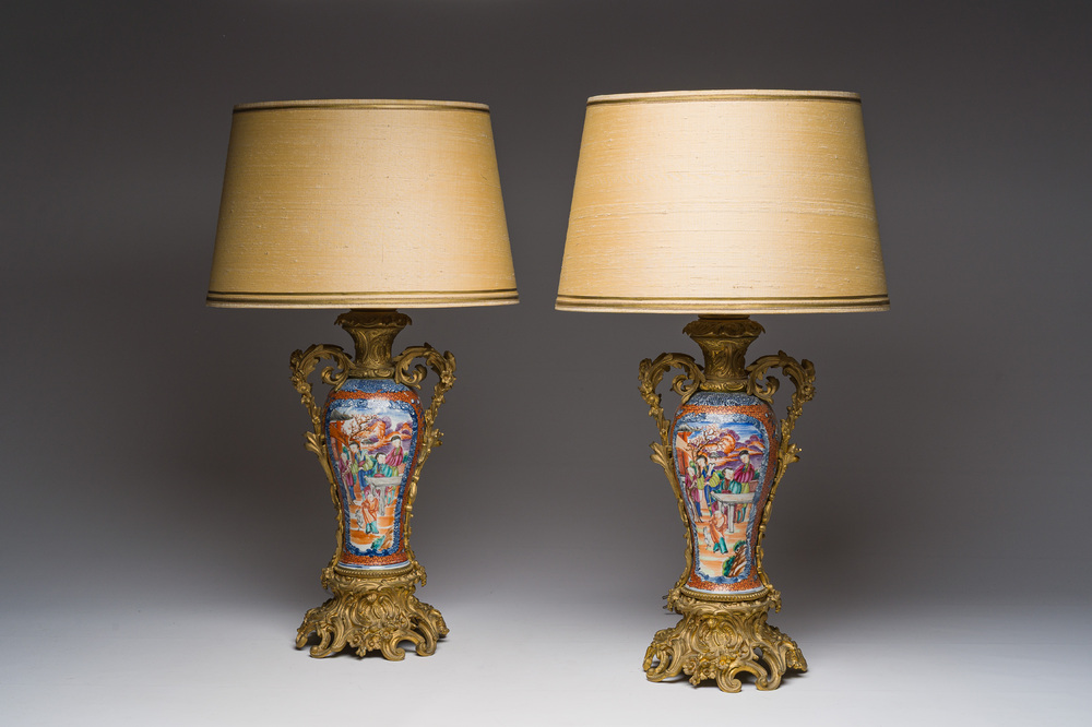 Een paar Chinese famille rose vazen met mandarijns decor met verguld bronzen monturen omgevormd tot lampen, Qianlong