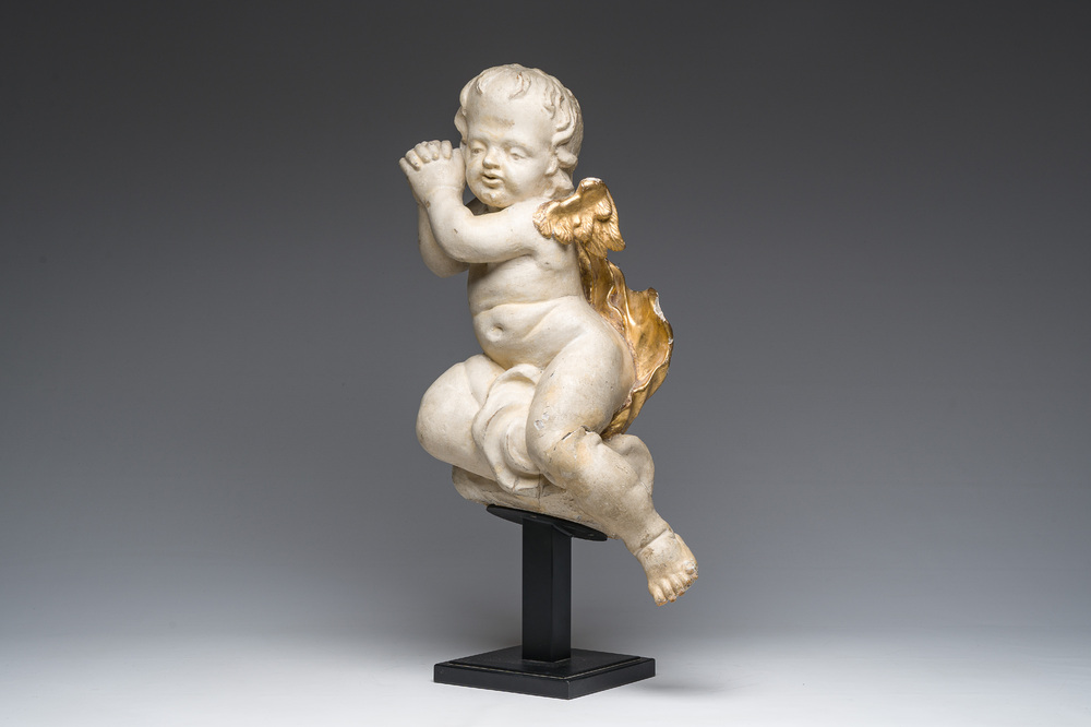 A Flemish patinated and gilt wooden angel mounted on a pedestal, 18th C.
