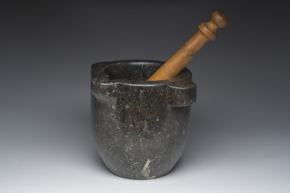 Een Franse zwartmarmeren vijzel met een latere houten stamper, 18de/19de eeuw