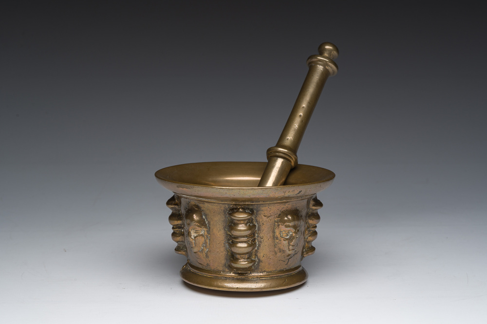 Een Franse bronzen vijzel met mascarons en stamper, vermoedelijk Le Puy-en-Velay, 16de/17de eeuw