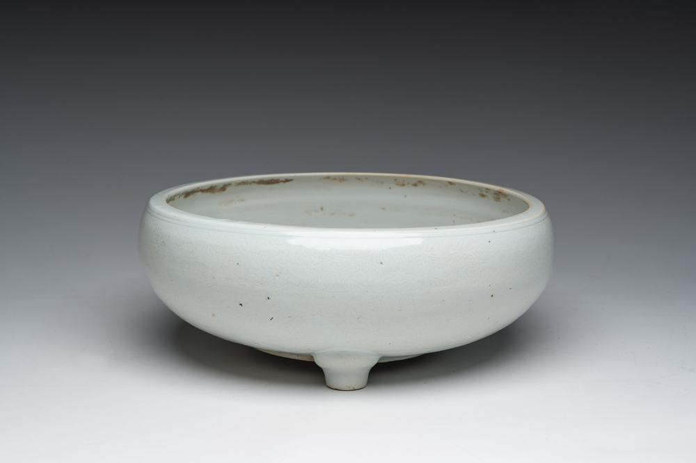 Een Chinese monochroom witte driepotige wierookbrander met onderglazuur decor, 19de eeuw