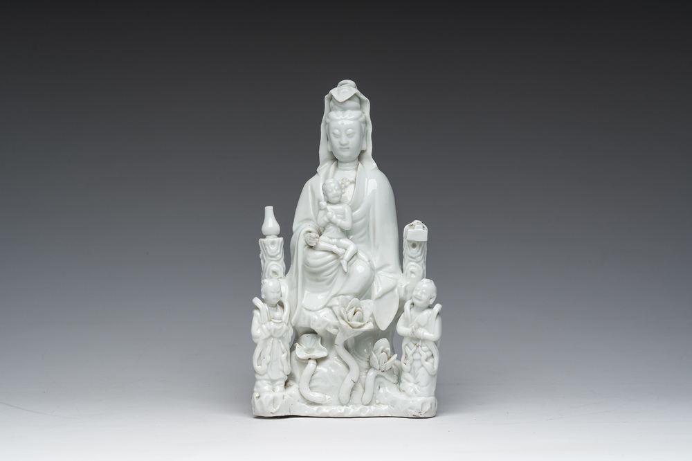 Een Chinese Dehua blanc de Chine figuur van Guanyin met dienaars, 19de eeuw
