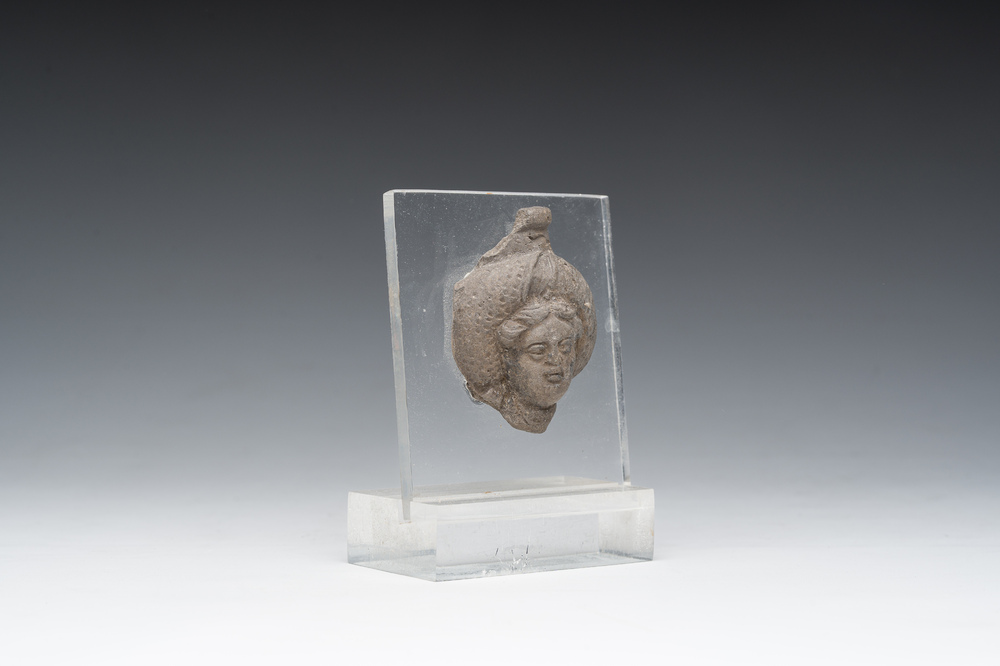Een Romeins terracotta fragment van een fles met een hoofd in reli&euml;f, vermoedelijk 1ste/3de eeuw