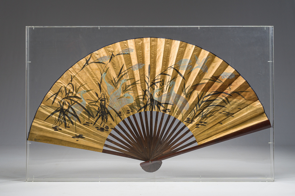 A large Japanese painted 'cranes in a landscape' folding fan luxuriously framed in a plexiglass box, signed, 20th C.