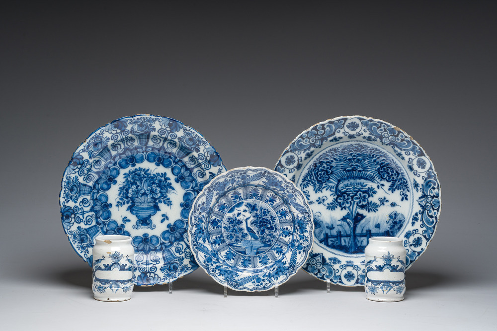 Three Dutch Delft blue and white dishes with a bird and floral design and two pharmacy jars, 18th C.