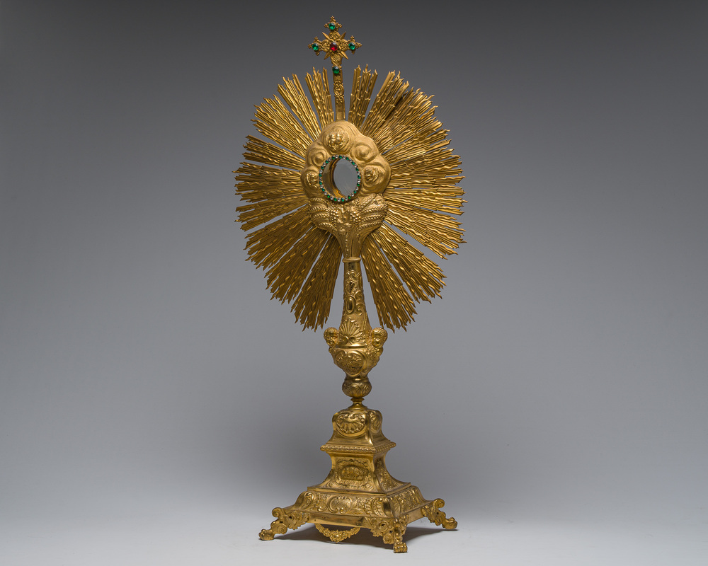 A large French gilt bronze monstrance decorated with cherubs amidst radiant clouds and set with glass stones, ca. 1900
