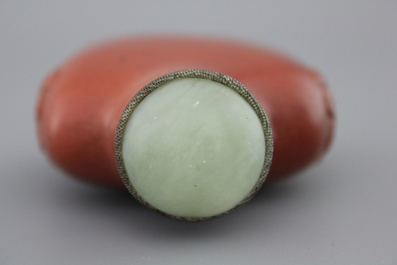 A Chinese polished gold stone snuff bottle with celadon jade lid