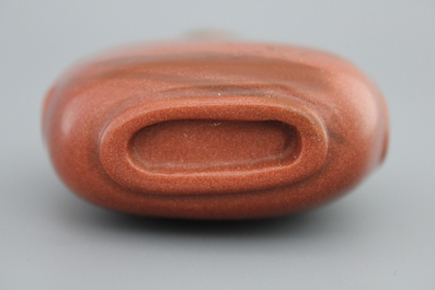 A Chinese polished gold stone snuff bottle with celadon jade lid