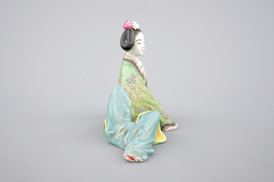 A Chinese famille rose porcelain figure of a reclining lady, 20th C