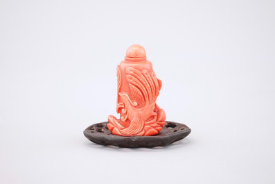 A Chinese carved red coral dragon snuff bottle on stand, 19th C.
