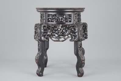 An elaborately carved Chinese hardwood vase stand with dreamstone insert, 19th C.