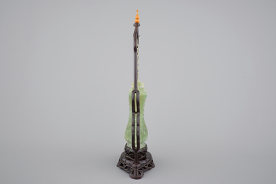 A Chinese carved green jadeite vase and cover on elaborate wooden stand, 19/20th C.