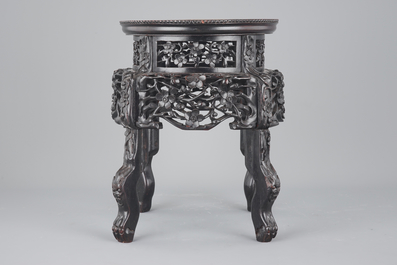 An elaborately carved Chinese hardwood vase stand with dreamstone insert, 19th C.