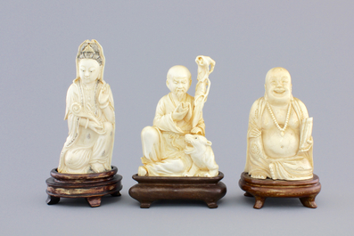 Three Chinese carved ivory figures on wooden stands, ca. 1900