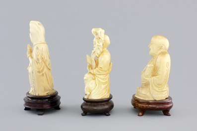 Three Chinese carved ivory figures on wooden stands, ca. 1900