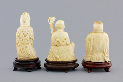 Three Chinese carved ivory figures on wooden stands, ca. 1900