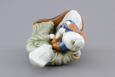 A Chinese celadon and blue-white biscuit group of a couple, Qianlong, 18th C.