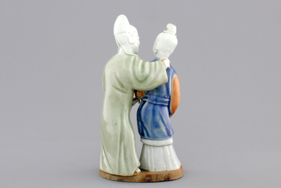 A Chinese celadon and blue-white biscuit group of a couple, Qianlong, 18th C.