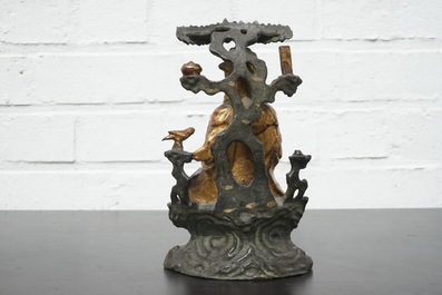 A Chinese bronze and gilt Buddha with child, seated beneath a bodhi tree, 17/18th C.