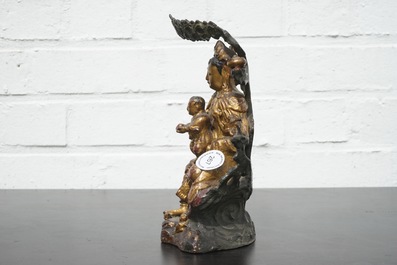 A Chinese bronze and gilt Buddha with child, seated beneath a bodhi tree, 17/18th C.