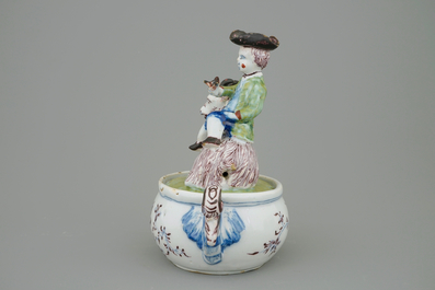 A Dutch Delft polychrome butter tub with a buckrider, 18th C.