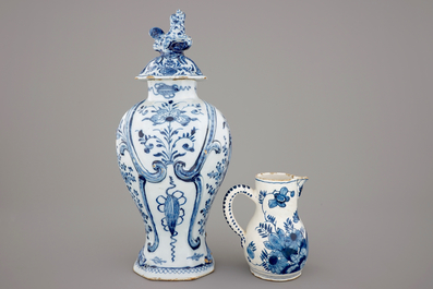 A large Dutch Delft blue and white vase and cover, a plate and a cream jug, 18th C.