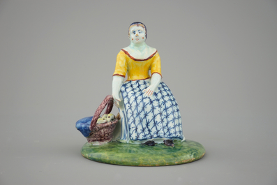 A polychrome Dutch Delft figure of a lady selling fish, 18th C.
