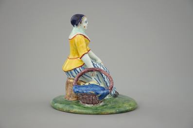 A polychrome Dutch Delft figure of a lady selling fish, 18th C.