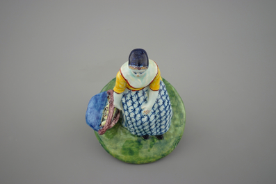 A polychrome Dutch Delft figure of a lady selling fish, 18th C.