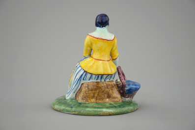 A polychrome Dutch Delft figure of a lady selling fish, 18th C.