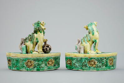 A pair of Chinese verte on biscuit foo dog joss stick holders, Kangxi