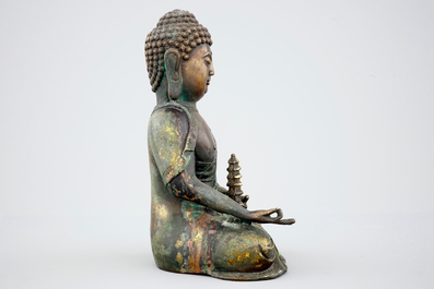A Sino-Tibetan gilt bronze figure of a seated Buddha, 19th C.