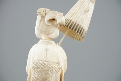 Een Japanse ivoren okimono, dame met parasol, 19e eeuw