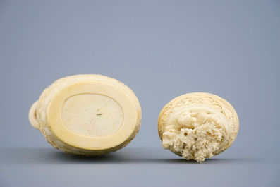 A Chinese carved ivory vase and cover on a wooden base, early 20th C.