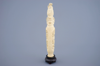 A Chinese carved ivory vase and cover on a wooden base, early 20th C.