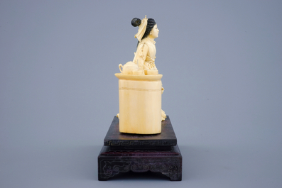 A Chinese carved ivory group of a lady near a tea table on a wood base, 19th C.