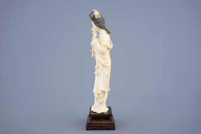 Een grote Chinese ivoren figuur van Guanyin op houten sokkel, begin 20e eeuw