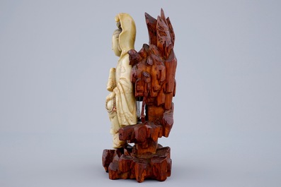 Une figure de Guanyin en pierre de savon sur socle en bois sculpt&eacute;, 18/19&egrave;me
