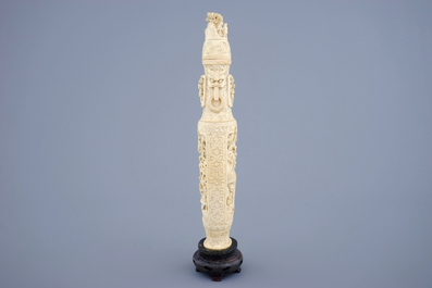 A Chinese carved ivory vase and cover on a wooden base, early 20th C.