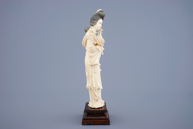 Een grote Chinese ivoren figuur van Guanyin op houten sokkel, begin 20e eeuw